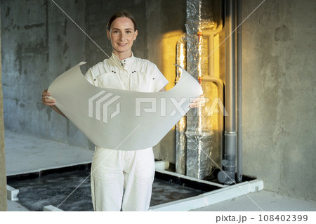 Female architect manages the construction site, supervising the progress of work and ensuring attention to detail for the implementation of the architectural plan. 108402399