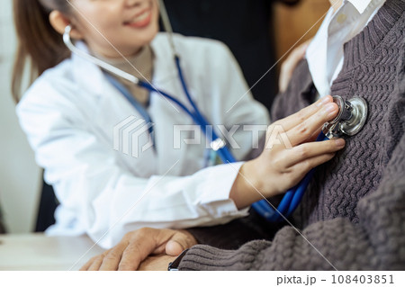 Doctor listens to heartbeat of older of retirement age to check their heart rate 108403851