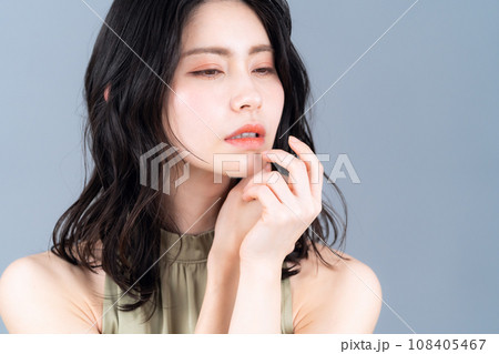 グレーバックでスキンケアをするミドルの女性 108405467