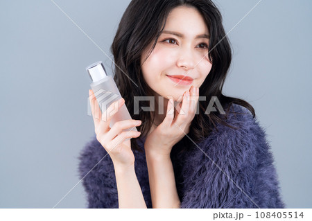 グレーバックでスキンケアをするミドルの女性 108405514