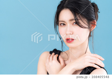 ブルーバックでスキンケアをするミドルの女性 108405548