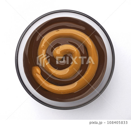 Caramel and chocolate cream swirl isolated on white background, top view Caramel and chocolate cream swirl isolated on white background, top view 108405833