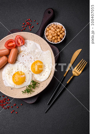 Fried chicken eggs, sausages, cherry tomatoes, chickpeas, spices, salt and herbs 108407055