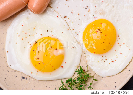 Fried chicken eggs, sausages, cherry tomatoes, chickpeas, spices, salt and herbs 108407056