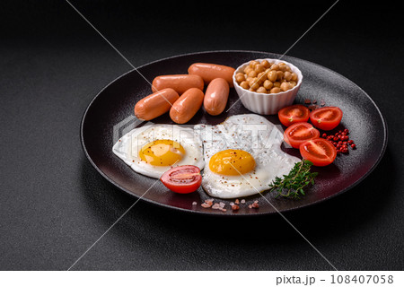 Fried chicken eggs, sausages, cherry tomatoes, chickpeas, spices, salt and herbs 108407058
