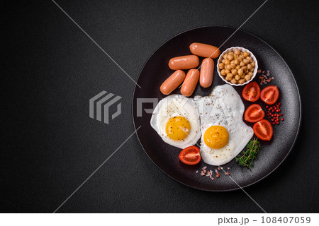 Fried chicken eggs, sausages, cherry tomatoes, chickpeas, spices, salt and herbs 108407059