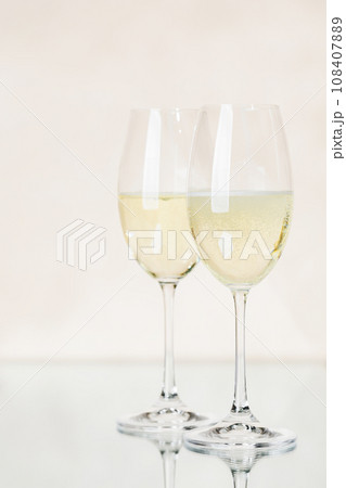 Two champagne glasses on a beige Two champagne glasses on a beige 108407889
