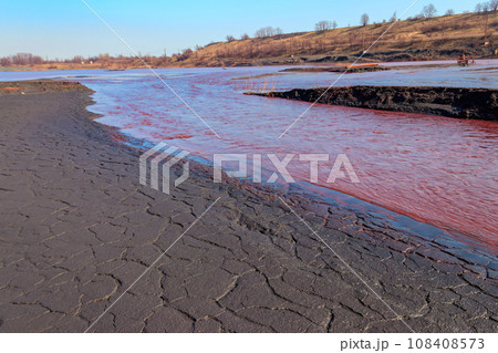 Technical settler of industrial water of mining industry in Kryvyi Rih, Ukraine. Red water polluted with iron ore waste. Discharge of process water in the sump after the iron ore beneficiation Technical settler of industrial water of mining industry in Kryvyi Rih, Ukraine. Red water polluted with iron ore waste. Discharge of process water in the sump after the iron ore beneficiation 108408573