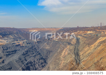 Huge iron ore quarry with working dump trucks and excavators 108408575
