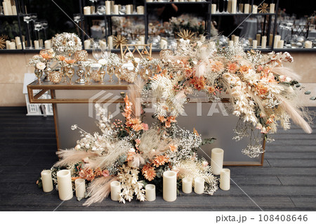 Front view of glamour table against mirrored wall with floating candles. Modern luxury wedding decor in expensive tones. Front view of glamour table against mirrored wall with floating candles. Modern luxury wedding decor in expensive tones. 108408646