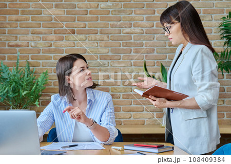 Two businesswomen talking and discussing in office 108409384