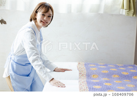 ベッドメイクをする可愛い女性 108409706