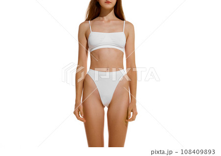 Front view. Cropped perfect naked body shape female body, breast, stomach dressed in underwear against studio background. Concept of dieting. Front view. Cropped perfect naked body shape female body, breast, stomach dressed in underwear against studio background. Concept of dieting. 108409893