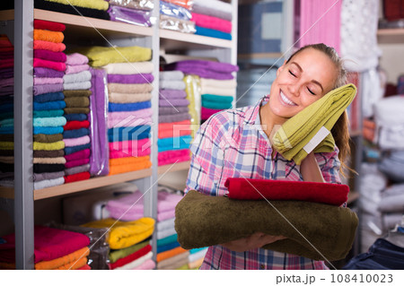 Girl deciding on choice of towels 108410023