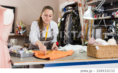 Portrait of woman designer who is doing new pattern for dress Portrait of woman designer who is doing new pattern for dress 108410132