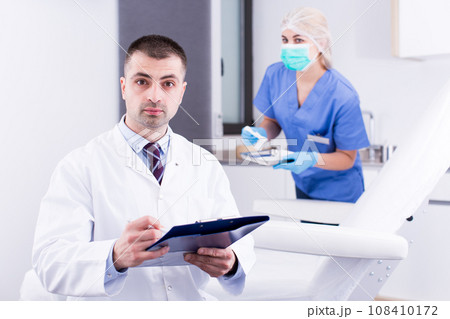 Cosmetician working with papers 108410172