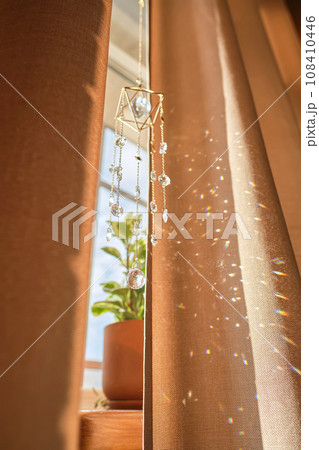 A beige curtain on the window and sunny spots. A beige curtain on the window and sunny spots. 108410446