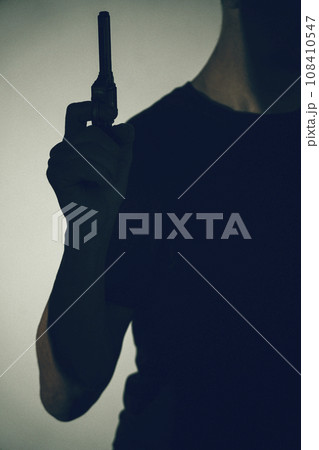 Gunman killer holding pistol artistic photo Gunman killer holding pistol artistic photo 108410547