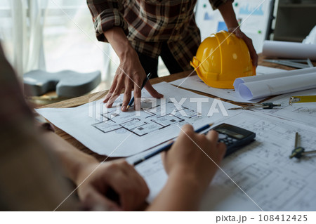 multi ethnic engineer brainstorming and measuring for cost estimating on blueprint and floor plan drawings about design architectural and engineering for houses and buildings. multi ethnic engineer brainstorming and measuring for cost estimating on blueprint and floor plan drawings about design architectural and engineering for houses and buildings. 108412425