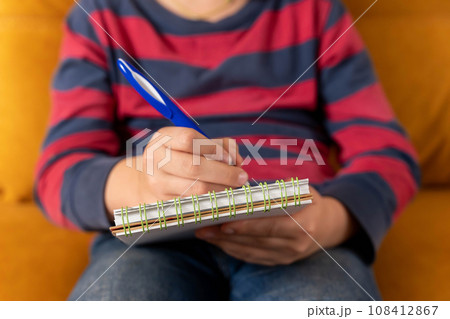 boy concentrating on drawing in his notebook in a moment of creative inspiration 108412867
