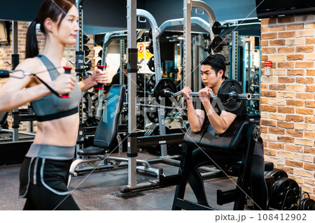 フィットネスジムでトレーニングする男女 フィットネスジムでトレーニングする男女 108412902