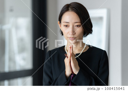 葬式に列席する女性 108415041
