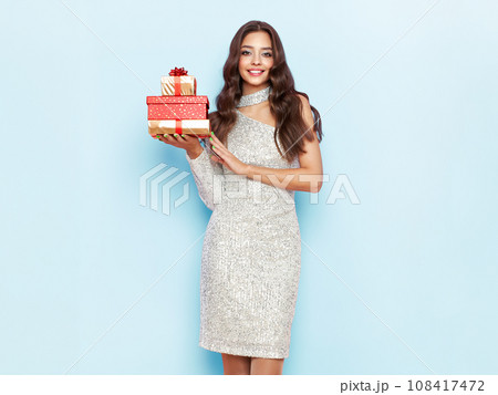 Beautiful woman in cocktail dress with gift boxes Beautiful woman in cocktail dress with gift boxes 108417472