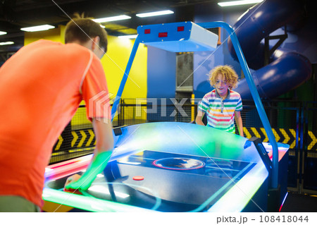 Kids play air hockey. Fun arcade games. Kids play air hockey. Fun arcade games. 108418044