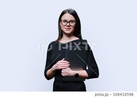 Portrait of young business woman holding laptop, on white background Portrait of young business woman holding laptop, on white background 108418596