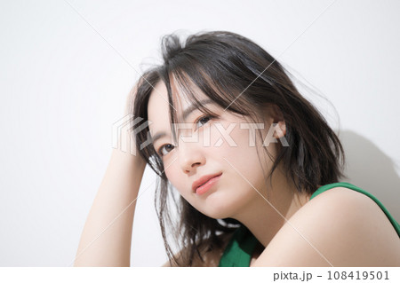 座って髪をかき上げる女性 顔のクローズアップ 座って髪をかき上げる女性 顔のクローズアップ 108419501