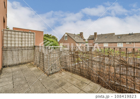 an outside area with fences and houses in the background on a cloudy day, as seen from behind it an outside area with fences and houses in the background on a cloudy day, as seen from behind it 108419823
