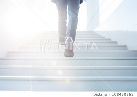 光に向かって階段を登るビジネスマン 光に向かって階段を登るビジネスマン 108420265