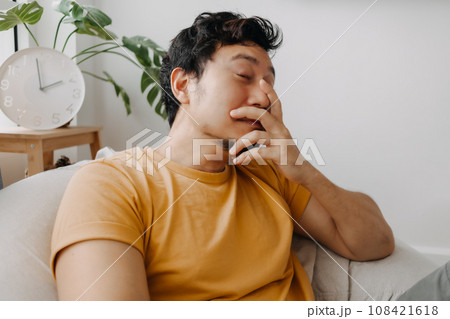 Laugh and shy asian man in yellow t-shirt on bean bag. Charming and relaxing 108421618