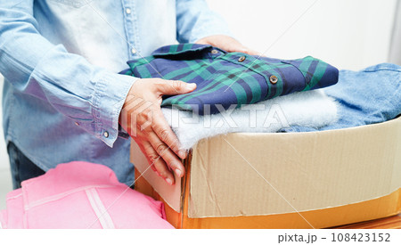 Clothes donations in cardboard box for volunteer. Clothes donations in cardboard box for volunteer. 108423152