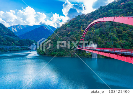 富山県黒部市　うなづき湖に架かる赤い湖面橋 108423400