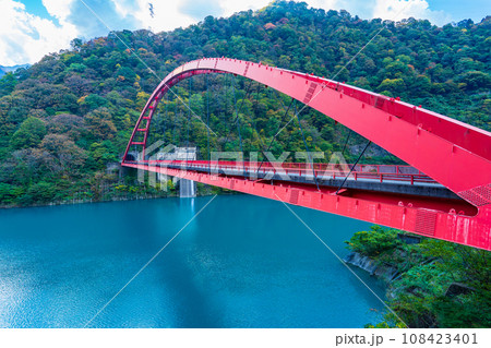 富山県黒部市　うなづき湖に架かる赤い湖面橋 108423401
