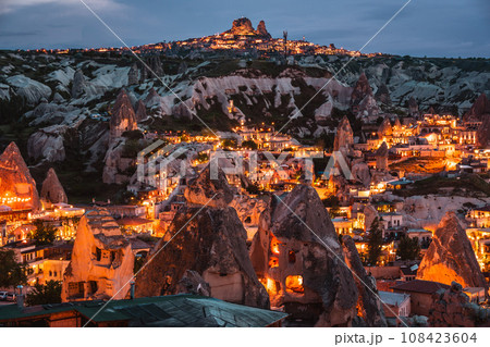 トルコの観光地カッパドキア中心地の展望台から見た奇岩群と岩石住居がオレンジ色に輝く美しい夜景 108423604
