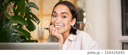 Beautiful young woman with happy smile, sitting in cafe with laptop, studying remotely, working online from distance Beautiful young woman with happy smile, sitting in cafe with laptop, studying remotely, working online from distance 108426895