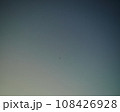 グラデーションが綺麗な夕方の空に飛行機が飛んでいる 108426928