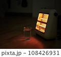 電熱ヒーターに照らされる白湯の入ったコップ 108426931