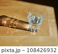水の入ったグラスに自然光が入って綺麗な模様ができている 108426932
