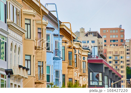 Row of houses with jutting out bay windows and escape ladders in city Row of houses with jutting out bay windows and escape ladders in city 108427220