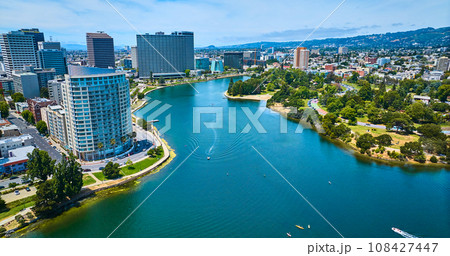 Oakland downtown skyscrapers beside Merritt Lake aerial with multiple boats on water Oakland downtown skyscrapers beside Merritt Lake aerial with multiple boats on water 108427447