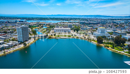 Lone sailboat on Lake Merritt with apartment building and courthouse with convention center aerial Lone sailboat on Lake Merritt with apartment building and courthouse with convention center aerial 108427593