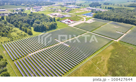High up view of solar farm in grassy field on bright summer day High up view of solar farm in grassy field on bright summer day 108427644