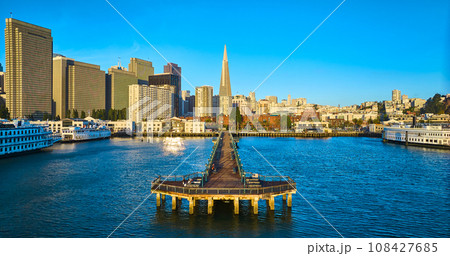 Aerial full Pier 7 with Transamerica Pyramid glowing golden at sunrise and wide view of city 108427685