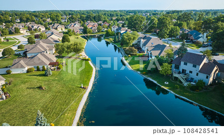 Long manmade pond between houses in neighborhood aerial 108428541