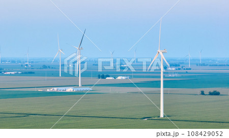 Early morning over farmland with wind farm turbines in hazy air aerial Early morning over farmland with wind farm turbines in hazy air aerial 108429052