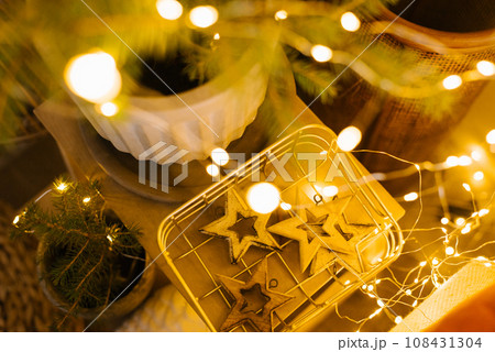 Christmas tree toys wooden stars in a basket with lights. Festive decor 108431304