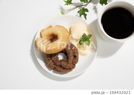 白い皿にのった二つのドーナツとバニラアイスとコーヒーとアイビー 108432021